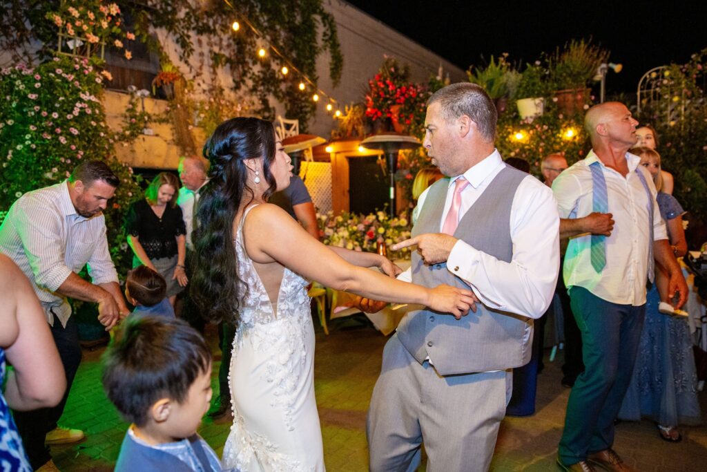 Bride and groom dancing with guests at their Arnoldi's Cafe wedding reception in Santa Barbara