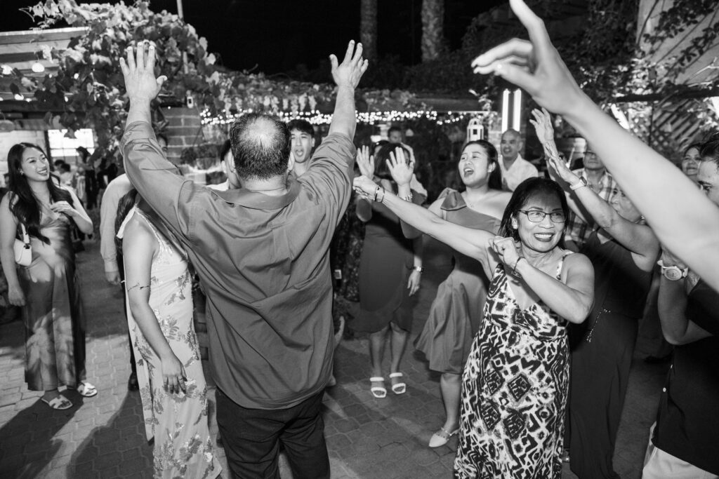 Black-and-white photo of guests with hands up on the dance floor at Arnoldi's Cafe, Santa Barbara