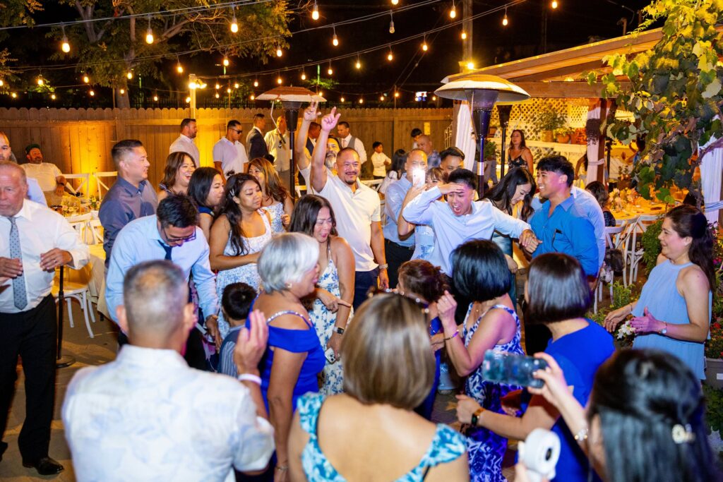 Packed wedding dance floor under string lights on the garden patio at Arnoldi's Cafe, Santa Barbara