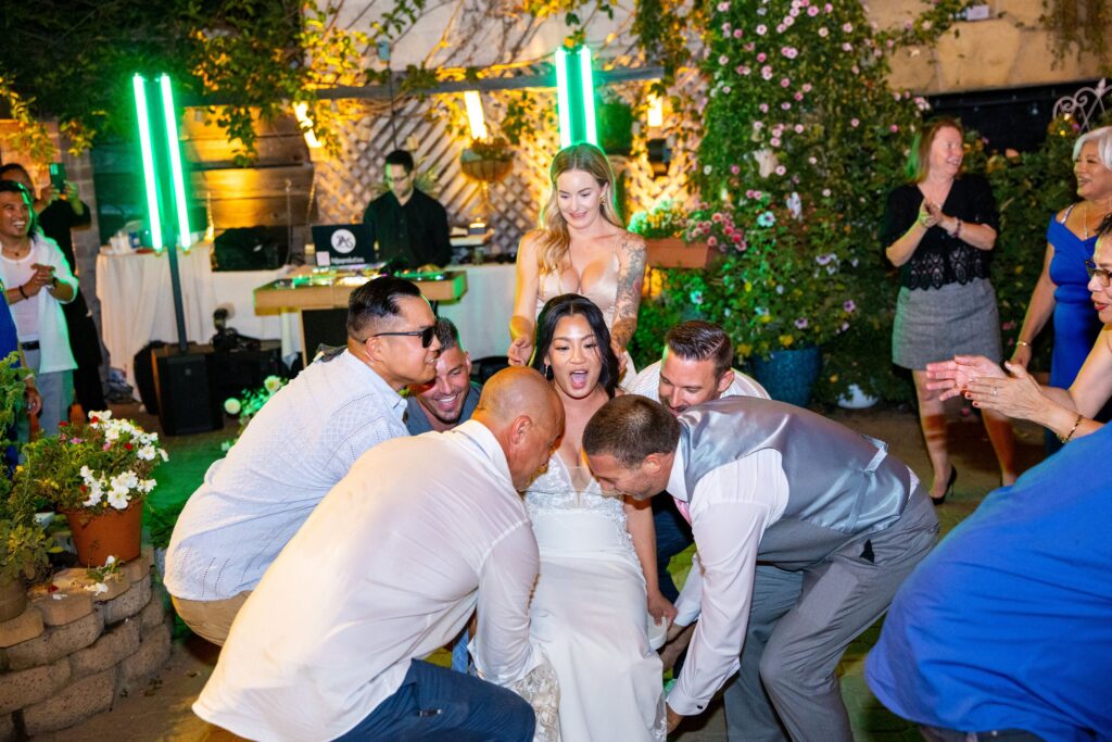 Wedding party dancing around the bride in front of the DJ booth at Arnoldi's Cafe, Santa Barbara