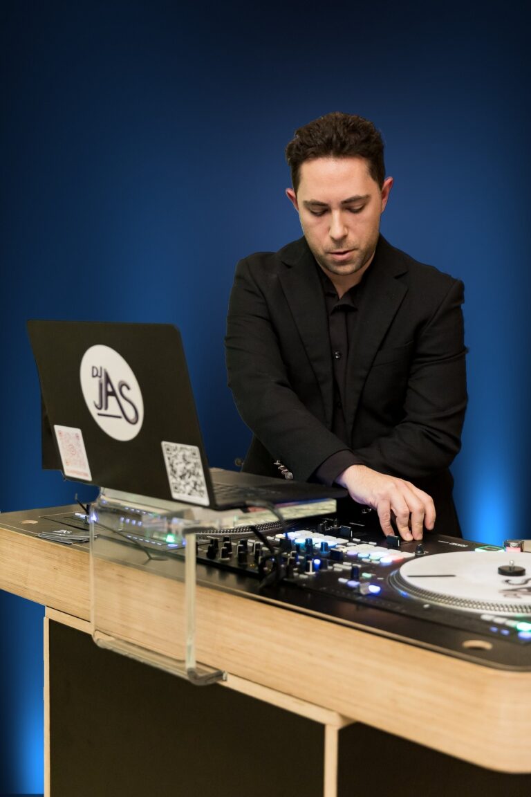 DJ JAS mixing at his DJ booth with his DJ JAS logo laptop at a wedding
