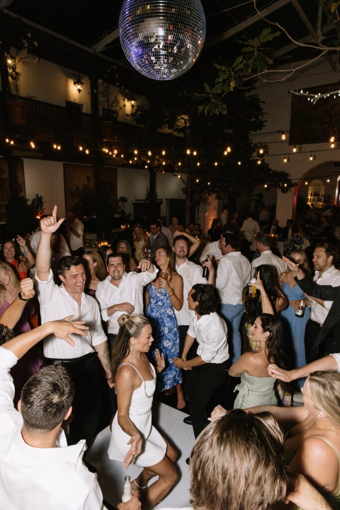 Guests dancing under the mirror ball at an El Paseo wedding