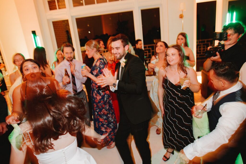 Groom dancing with guests as the bride spins at a Sherwood Country Club wedding